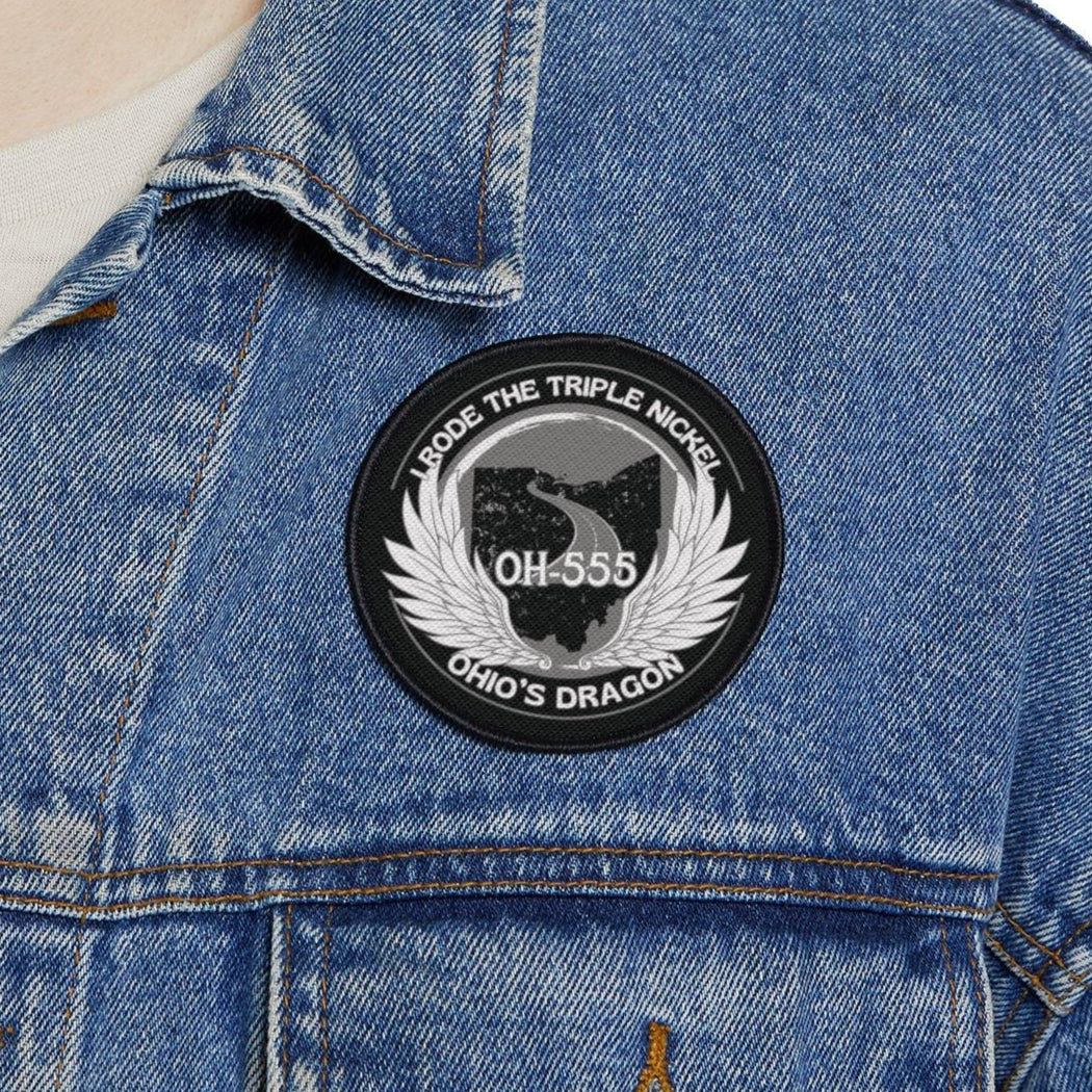 Person wearing a blue denim jacket with a patch on a white background