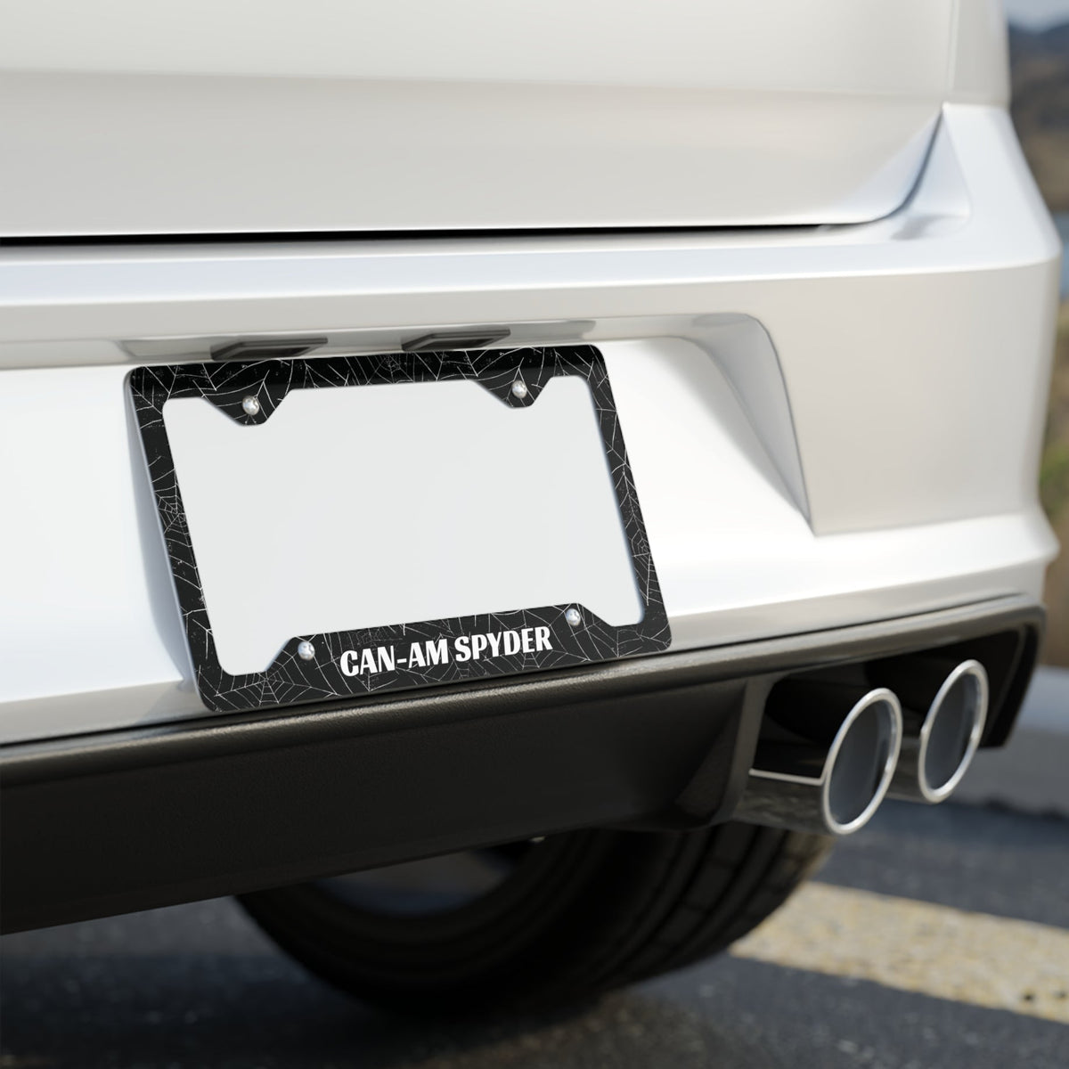 Close-up of a car's license plate frame with 'CAN-AM SPYDER' text on a blurred background.