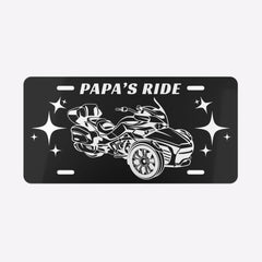 Black license plate with a graphic of a vehicle and 'Papa's Ride' text on a white background