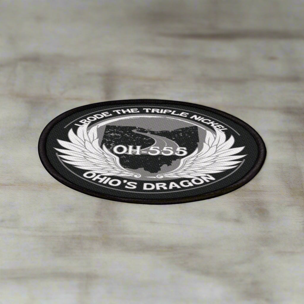 Round black and white sticker with text and wings on a white background
