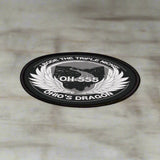 Round black and white sticker with text and wings on a white background