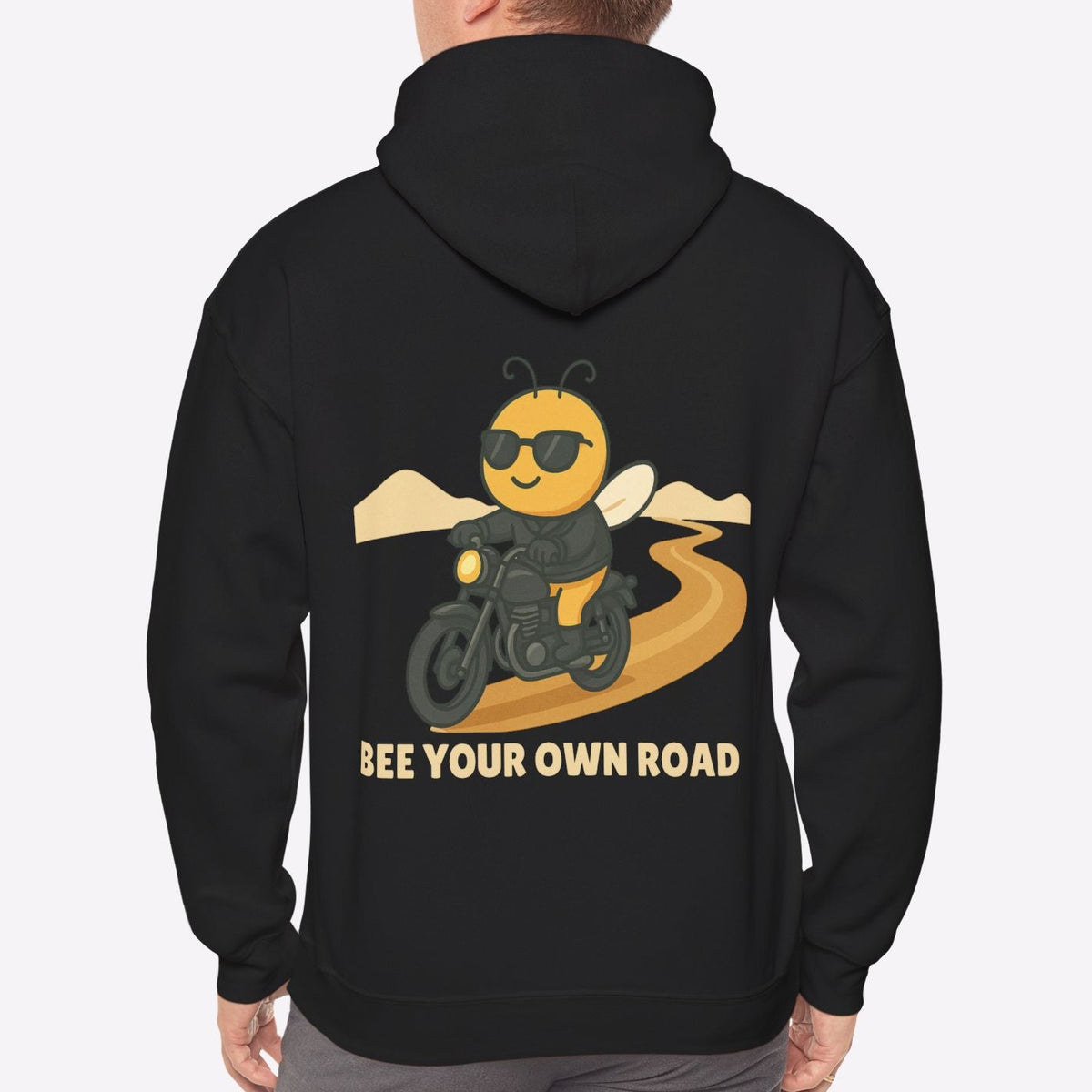 Person wearing a black hoodie with a bee graphic and text on the back, on a white background