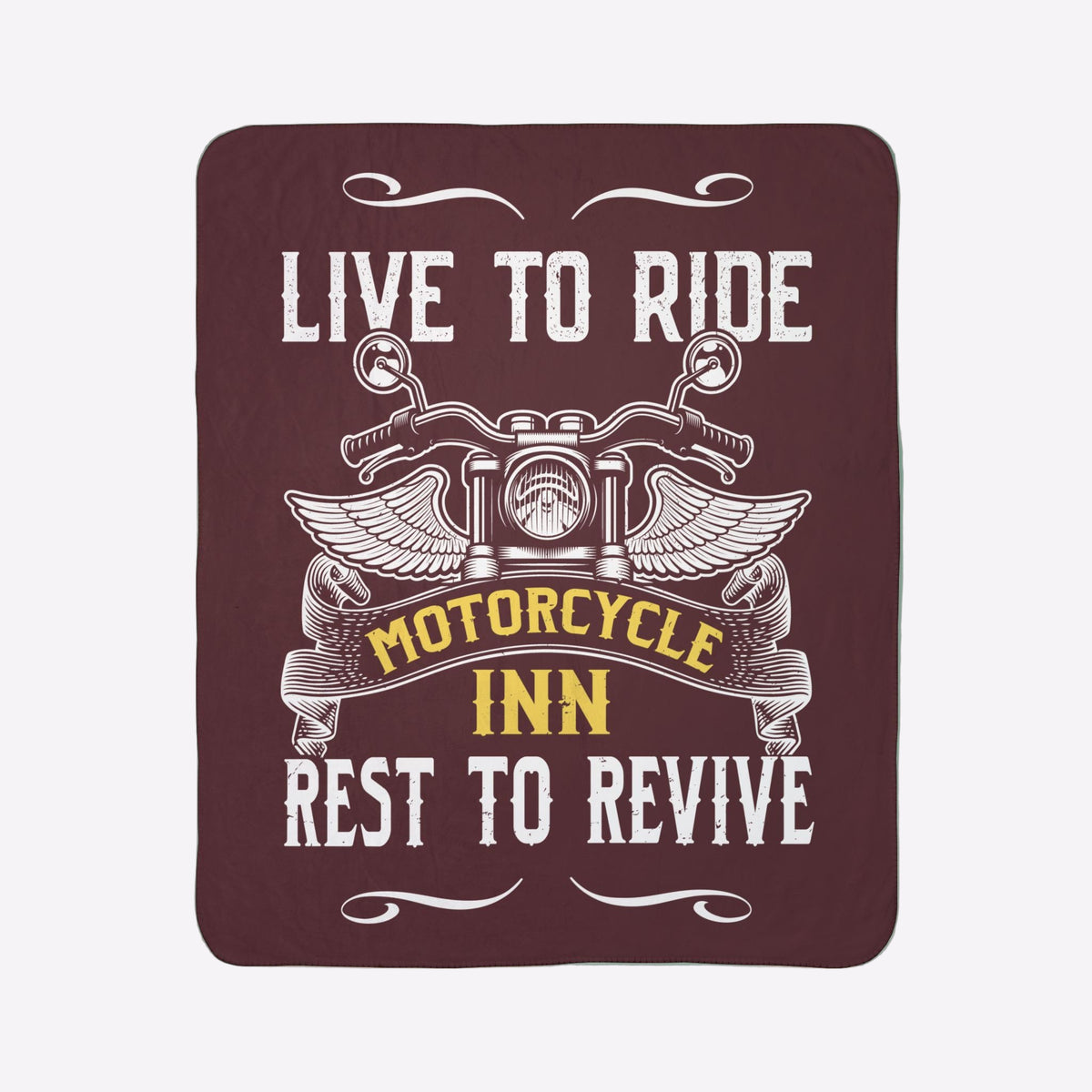Blanket with motorcycle design and text 'Live to Ride, Motorcycle Inn, Rest to Revive' on a green wall.