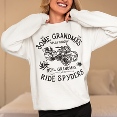 Person wearing a white sweatshirt with a graphic and text, standing in a bedroom.