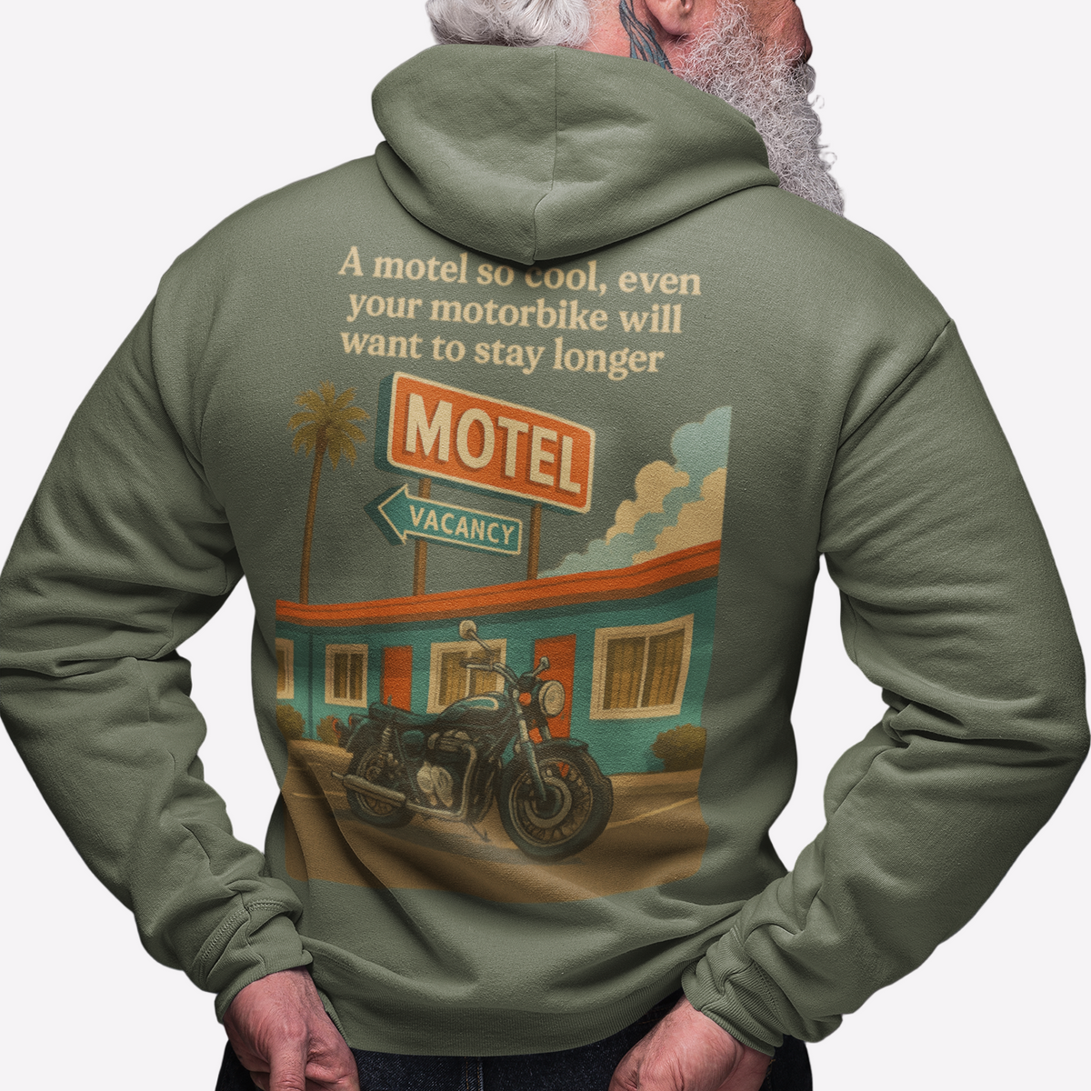 Person wearing a green hoodie with a graphic design on the back, featuring a motel and motorcycle.